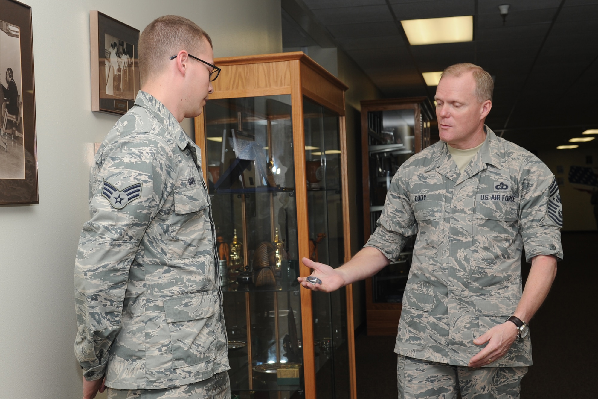 GOODFELLOW AIR FORCE BASE, Texas – Chief Master Sgt. of the Air Force James Cody coins Senior Airman Devan D. Smith, 17th Training Support Squadron intelligence training system administrator, during Cody’s visit to the 17th Training Wing April 3. Smith earned Senior Airman below-the-zone as well as the 2014 17th Training Group Support Airman of the Year and 2014 Air Education and Training Command Intelligence, Surveillance and Reconnaissance Contributor of the Year. (U.S. Air Force photo/ Staff Sgt. Laura R. McFarlane)