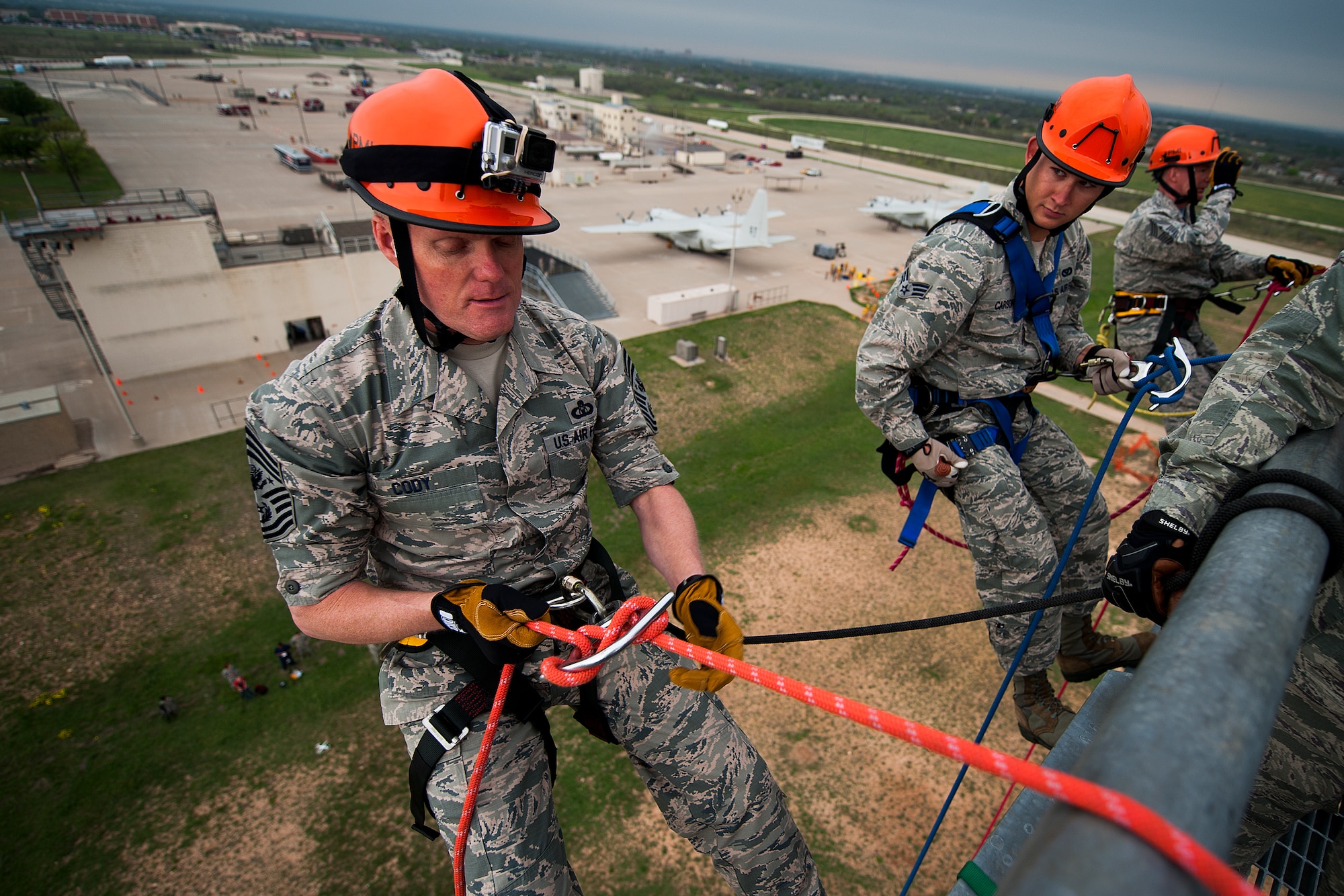 GOODFELLOW AIR FORCE BASE, Texas – Chief Master Sgt. of the Air Force James Cody, left, prepares to rappel down a 90-foot tower with Senior Airman Cody Carson, 312th Training Squadron firefighting student, center, and Chief Master Sgt. Thomas F. Good, 17th Training Wing Command Chief, right, at the Louis F. Garland Department of Defense Fire Academy April 3. Cody toured the fire academy and observed different aspects of fire protection training while visiting with staff and students. (U.S. Air Force photo/ Airman 1st Class Devin Boyer)