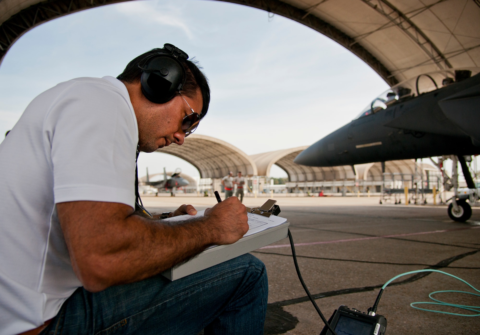 Irvin Fontanes, Air Force Seek Eagle office, takes notes during an electromagnetic interference and compatibility test of a LITENING pod on an F-15 Eagle March 18 at Eglin Air Force Base, Fla.  The test will measure the frequencies put out by the pod and ensure those transmissions do not interfere with the safe operation of the aircraft.  While the testing is performed on the ground, the aircraft is running with aircrew performing various flight procedures and reporting any interference.  This test is directly related to the AFSEO mission of ensuring new warfighter capabilities through the application and transfer of aircraft-store compatibility expertise.  (U.S. Air Force photo/Samuel King Jr.)