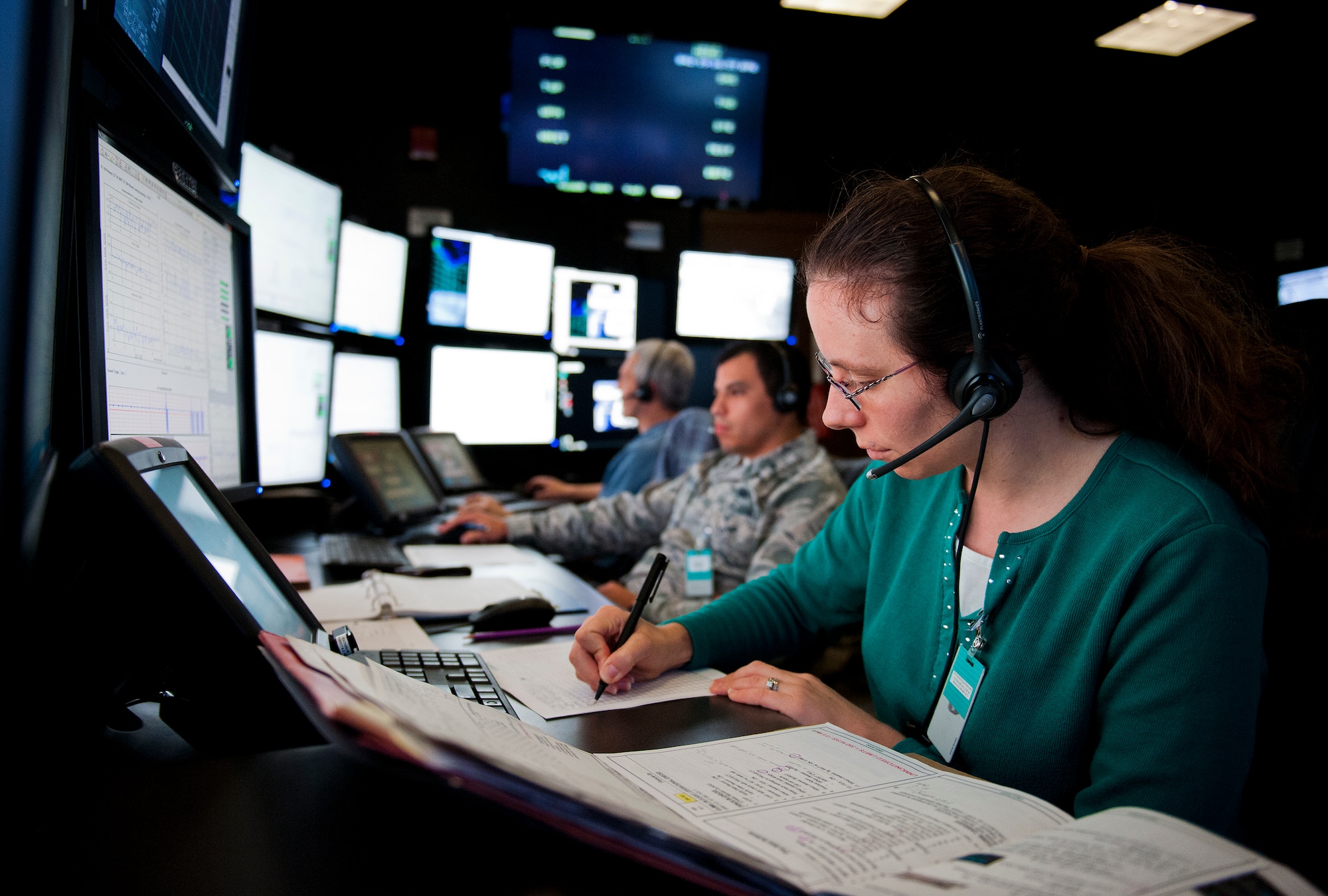 Julie Saladin and 1st Lt. Christian Delgadillo, Air Force Seek Eagle office, take notes and monitor a flutter test from the Central Control Facility at Eglin Air Force Base, Fla., Feb. 11. An aircraft flutter test assures wing vibration is within safe limits based on environmental variables such as airspeed, altitude and G-force.  AFSEO is considered the center of excellence for aircraft store capability.  Their mission is to ensure new warfighter capabilities through the application and transfer of aircraft-store compatibility expertise. (U.S. Air Force photo/Samuel King Jr.)