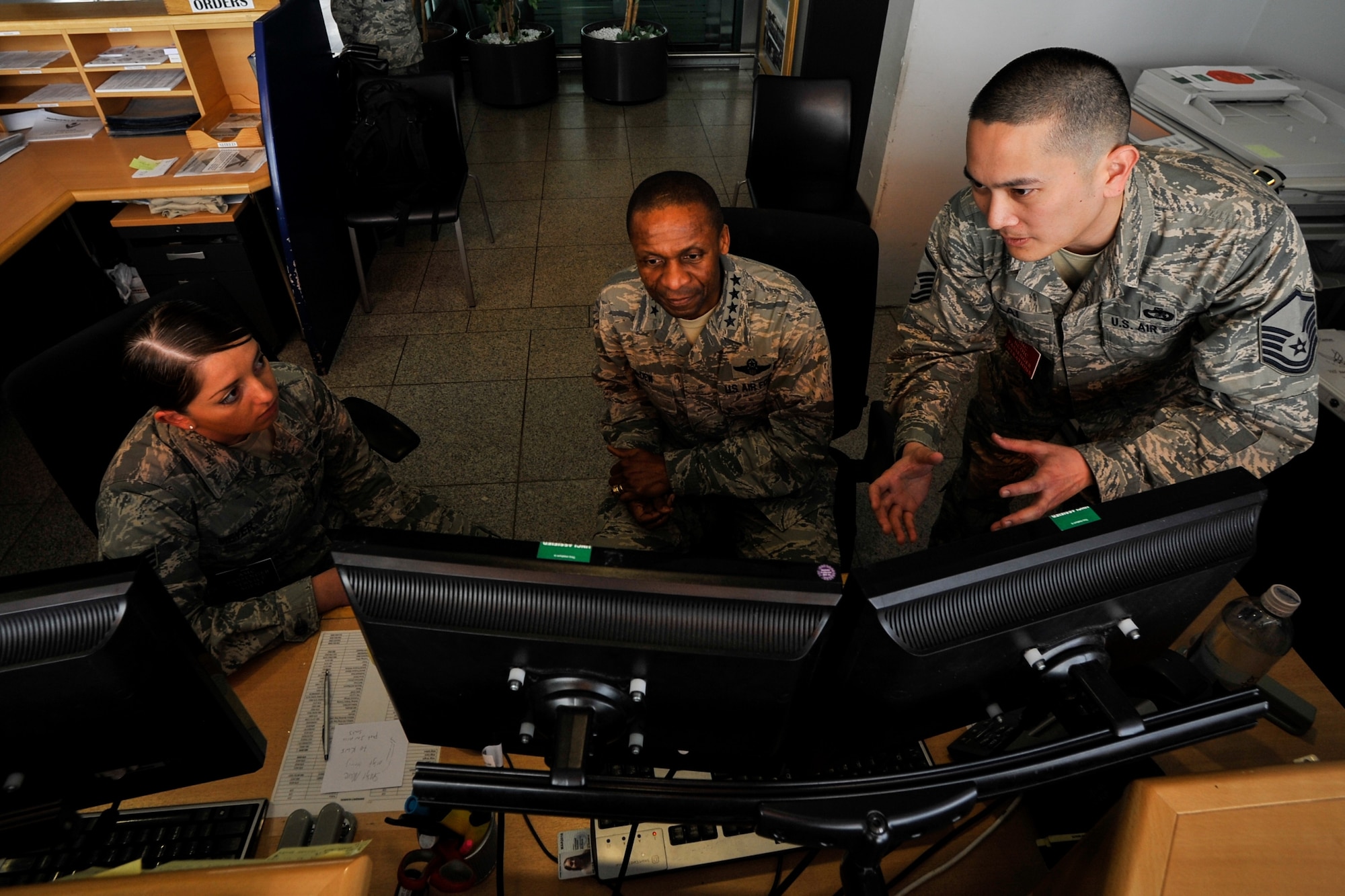 General Darren W. McDew, Air Mobility Command commander, receives a briefing on passenger processing from Senior Airman Lindsay Meyer (left), 721st Aerial Port Squadron Ramstein Passenger Terminal service agent, and Master Sgt. Tsoon Lai, 721st APS RST passenger service operations supervisor at Ramstein Air Base, Germany, March 30, 2015. The general not only visited Airmen at Ramstein, but had an opportunity to process a customer through the 721st APS Ramstein Passenger Terminal. (U.S. Air Force photo/Senior Airman Nicole Sikorski)
