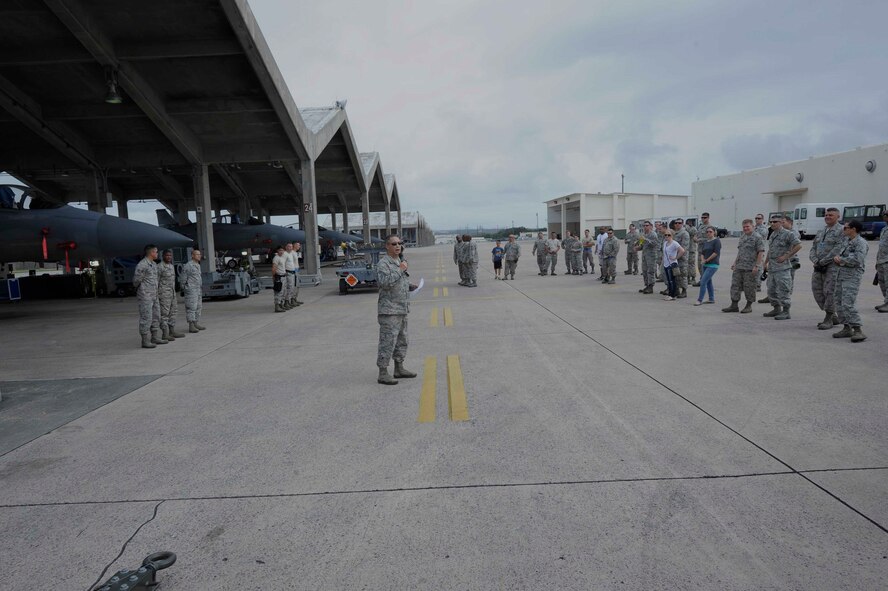 U.S. Air Force Senior Master Sgt. Shannon Davis, 18th Maintenance Group weapons standardization superintendent, speaks to the crowd just before the weapons load competition beings at Kadena Air Base, Japan, April 6, 2015.The competition tests the team's ability to load weapons on F-15C Eagles in a fast and safe manner. This competition was held between the 44th and 67th Aircraft Maintenance Units of the 18th AMXS. (U.S. Air Force photo by Airman 1st Class Zackary A. Henry/Released)