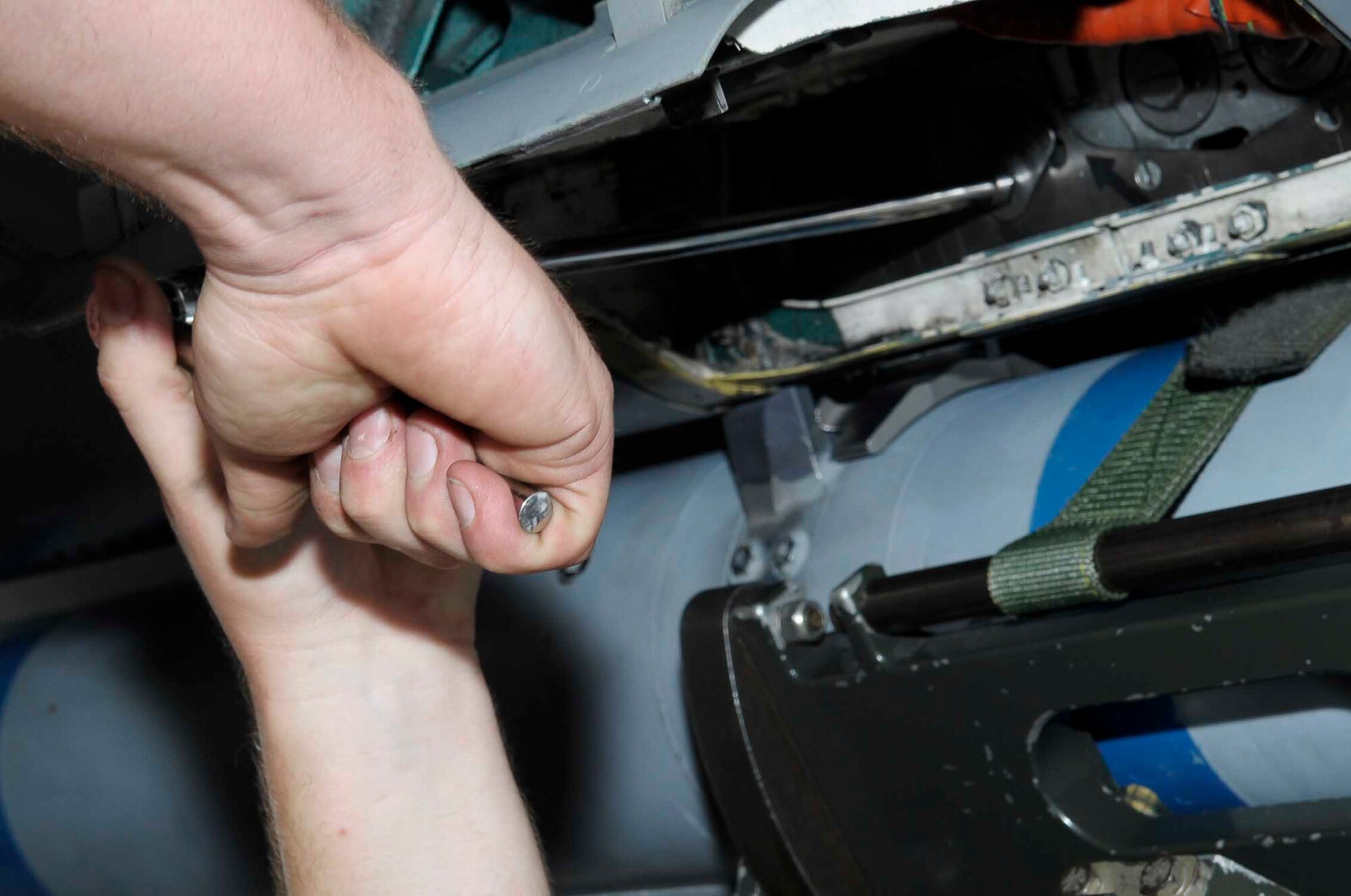 An Airman from the 67th Aircraft Maintenance Unit secures a weapon on an F-15C Eagle during a weapons load competition at Kadena Air Base, Japan, April 6, 2015. The competition tests the team's ability to load weapons on an F-15C Eagle in a fast and safe manner while increasing morale through healthy competition. (U.S. Air Force photo by Airman 1st Class Zackary A. Henry/Released)
