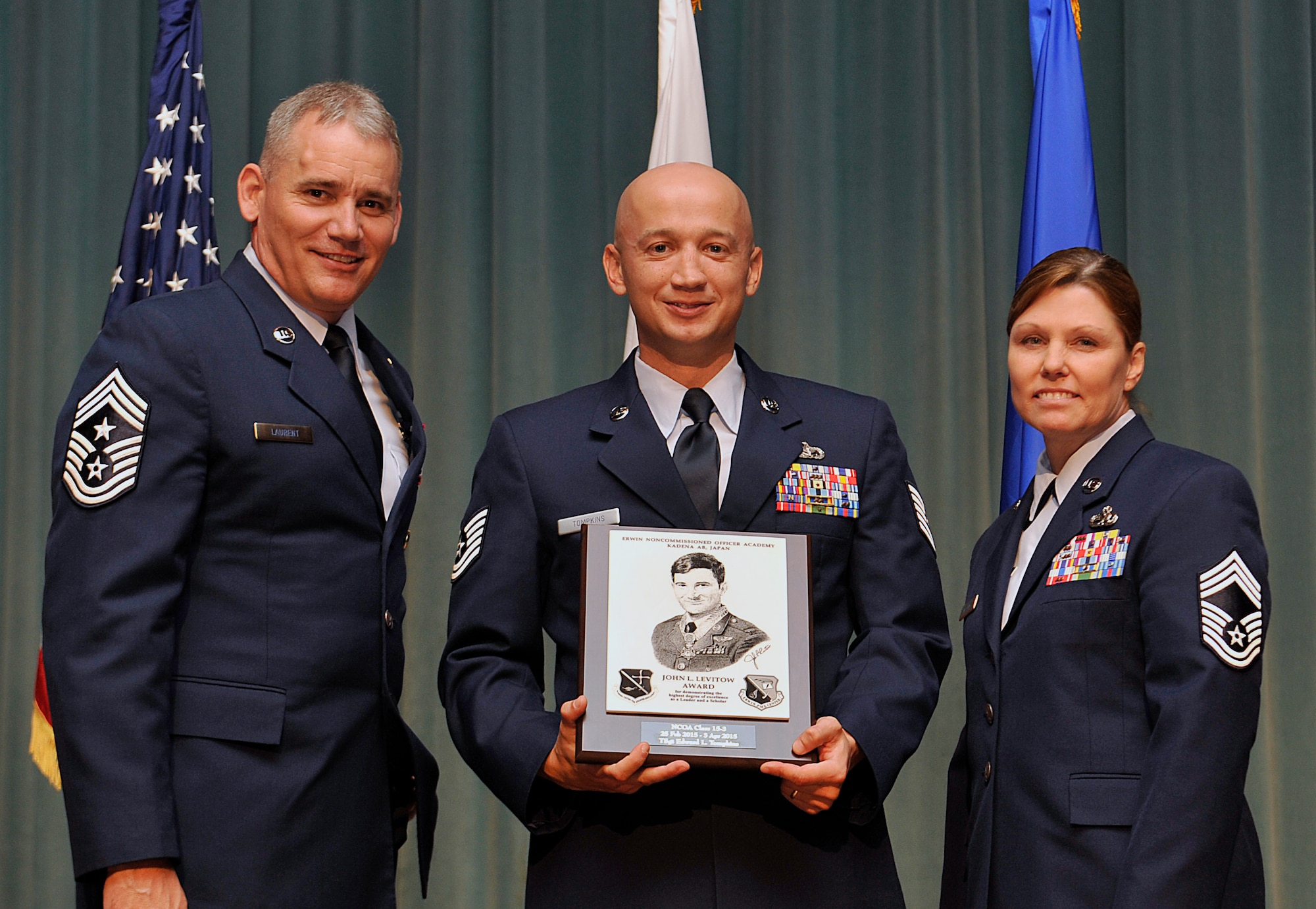 U.S. Air Force Tech. Sgt. Edward Tompkins, Detachment 1, 554th Red Horse Squadron at Andersen Air Base, Guam, receives the John L. Levitow Award during the NCO Academy Class 15-3 graduation ceremony at the Keystone Theater on Kadena Air Base, Japan, April 3, 2015. This award, named in memory of Medal of Honor recipient Airman 1st Class John L. Levitow, is presented to the most outstanding member of professional military education classes and denotes superior achievement as both a leader and a scholar. (U.S. Air Force photo by Naoto Anazawa)