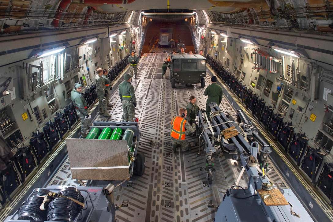 Airmen load cargo on a C-17 Globemaster III aircraft during Rapid Raptor training at the Joint Mobility Center on Joint Base Elmendorf-Richardson, Alaska, March 26, 2015.