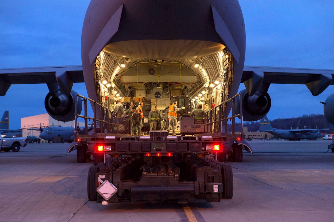Airmen load cargo on a C-17 Globemaster III aircraft during Rapid Raptor training at the Joint Mobility Center on Joint Base Elmendorf-Richardson, Alaska, March 26, 2015.