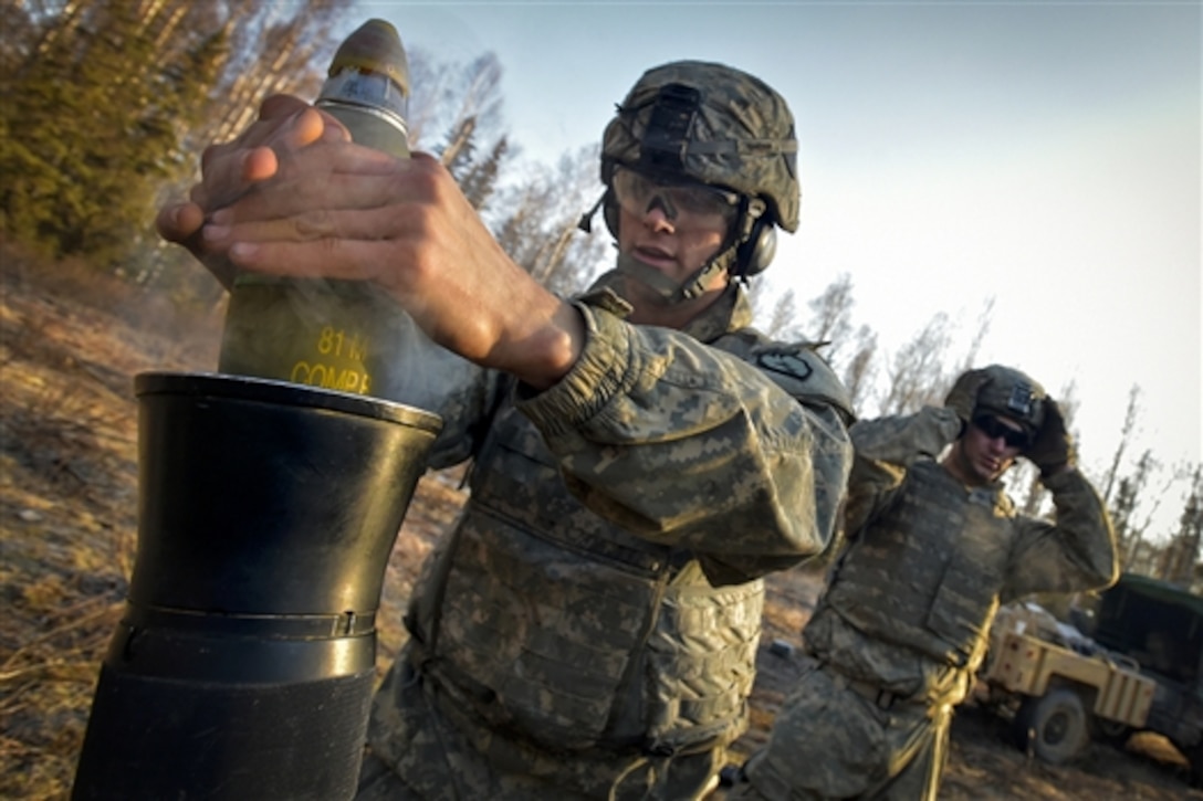 Army Pvt. Riley Eggeman, left, prepares to load an 81-mm mortar on Joint Base Elmendorf-Richardson, Alaska, April 3, 2015. Eggeman is assigned to the 25th Infantry Division's 1st Battalion, 501st Infantry Regiment, 4th Infantry Brigade Combat Team, Alaska.