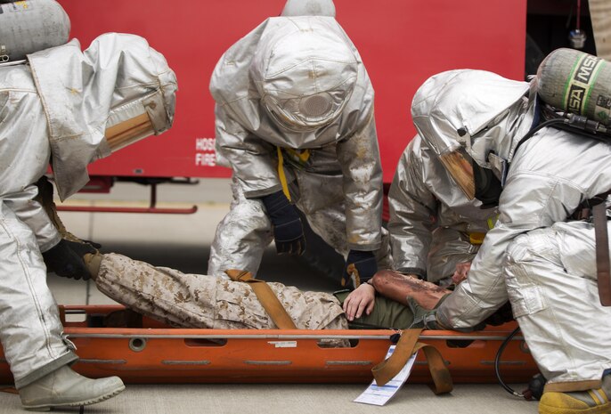 Aircraft Rescue Firefighters with Headquarters and Headquarters Squadron work together to evacuate a casualty during the mass casualty exercise aboard Marine Corps Air Station Iwakuni, Japan, April 3, 2015. MCAS Iwakuni conducted the exercise in preparation for the Japan Maritime Self-Defense Force/MCAS Iwakuni Friendship Day 2015 Air Show. The exercise simulated an aircraft crash and oil spill in a crowded area.