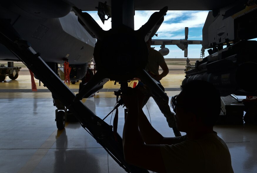 U.S. Air Force Airman 1st Class Huy Diep, 27th Special Operations Maintenance Squadron MQ-9 Reaper and CV-22 Osprey armament shop, inspects an MQ-9 during a load competition April 6, 2015 at Cannon Air Force Base, N.M. Historically, load crews within the Air Force are based on a three-man concept; four-man for bombers. Inspections and functional checks are part of routine weapon loading on aircraft. (U.S. Air Force photo/Staff Sgt. Alex Mercer)