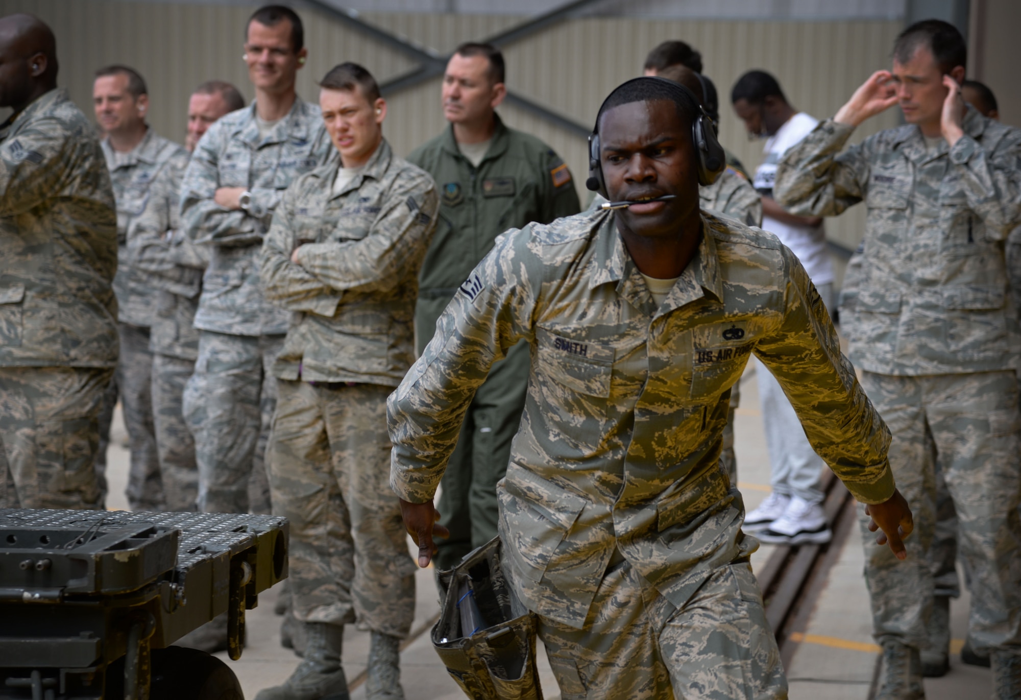 U.S. Air Force Staff Sgt. Olin Smith, 27th Special Operations Maintenance Squadron AC-130 armament shop, moves quickly while directing crew members during a load competition April 6, 2015 at Cannon Air Force Base, N.M. Smith took lead of his three-man crew during the first Air Force Special Operations Command load competition. (U.S. Air Force photo/Staff Sgt. Alex Mercer)