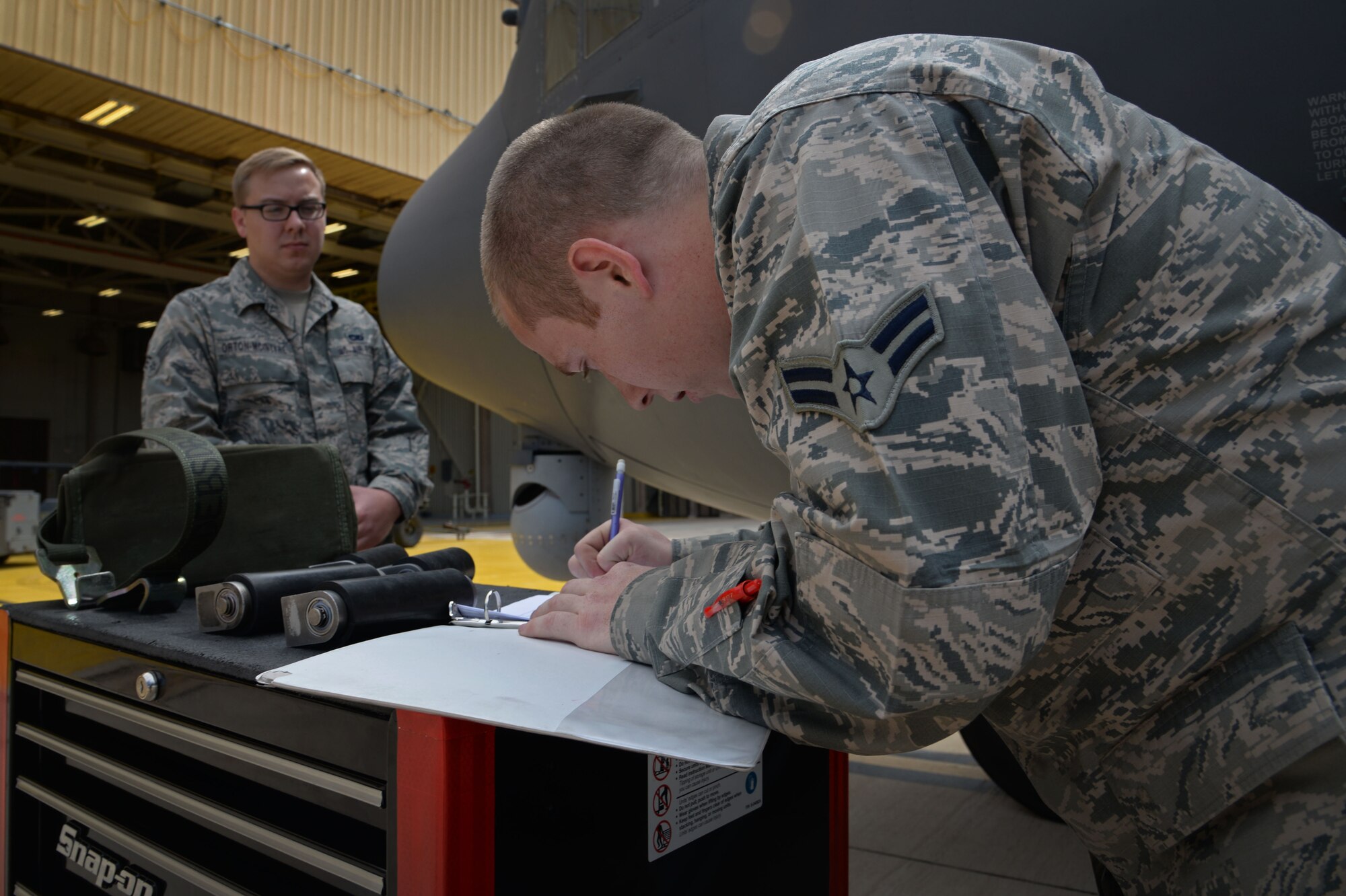 U.S. Air Force Airman 1st Class David Coulter, 27th Special Operations Maintenance Squadron AC-130 armament shop, annotates information in aircraft forms pertaining to what was loaded during a load competition April 6, 2015 at Cannon Air Force Base, N.M. Both teams moved quickly and efficiently to claim the title of Air Force Special Operations Command’s first load crew of the year. (U.S. Air Force photo/Staff Sgt. Alex Mercer)