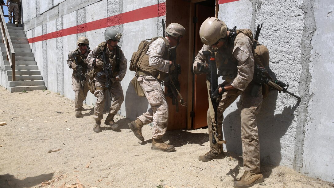 Marines with Charlie Company, 1st Reconnaissance Battalion, rush into a compound after breaching a door during a live-fire raid at Range 226 aboard Marine Corps Base Camp Pendleton, California, April 1, 2015. The company conducted the live-fire exercise as part of a pre deployment workup in support of the 13th Marine Expeditionary Unit. (U.S. Marine Corps photo by Sgt. Joseph Scanlan / released)