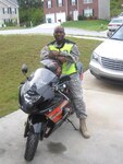 First Lt. Clifton Walker stands next to the motorcycle he was riding the day he had to put what he’d learned at the Guard’s Motorcycle Safety Course to the test