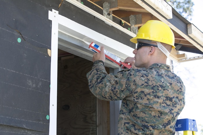 Cpl. Thomas Jenkins, a combat engineer with 8th Engineer Support Battalion, 2nd Marine Logistics Group, applies caulk to a door frame during a construction project aboard Camp Lejeune, N.C., March 31, 2015. Marines with 8th ESB built a storage facility for the unit’s martial arts equipment as training for an upcoming deployment. The Marines will use the same skills to construct schools and other facilities overseas. (U.S. Marine Corps photo by Cpl. Elizabeth A. Case/Released)