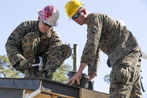 Marines with 8th Engineer Support Battalion, 2nd Marine Logistics Group, nail felt paper, a water-proofing and insulating material, to the roof of a building aboard Camp Lejeune, N.C., March 31, 2015. Engineers with 8th ESB built a storage facility for the unit’s martial arts equipment as training for an upcoming deployment. The Marines will use the same skills to construct schools and other facilities overseas. (U.S. Marine Corps photo by Cpl. Elizabeth A. Case/Released)