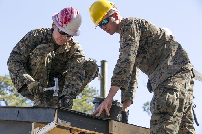 Marines with 8th Engineer Support Battalion, 2nd Marine Logistics Group, nail felt paper, a water-proofing and insulating material, to the roof of a building aboard Camp Lejeune, N.C., March 31, 2015. Engineers with 8th ESB built a storage facility for the unit’s martial arts equipment as training for an upcoming deployment. The Marines will use the same skills to construct schools and other facilities overseas. (U.S. Marine Corps photo by Cpl. Elizabeth A. Case/Released)