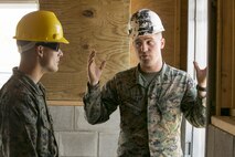 Sgt. Christopher Panko, right, and Cpl. Thomas Jenkins, combat engineers with 8th Engineer Support Battalion, 2nd Marine Logistics Group, discuss construction of a door frame aboard Camp Lejeune, N.C., March 31, 2015. Marines with 8th ESB built a storage facility for the unit’s martial arts equipment as training for an upcoming deployment. “In a few short weeks we’re going to deploy to South America and build a bunch of buildings down there – schools for some of the kids,” said Panko. “The way we built this from the ground up replicates how the buildings are going to be down there. This is a good starter project for the Marines, and for myself, to catch back up with construction and do it the right way. When we get to South America, we’re not really playing any games. We can go there, build and get out of there.” (U.S. Marine Corps photo by Cpl. Elizabeth A. Case/Released)