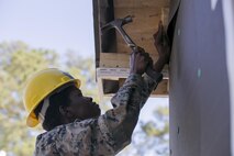 Cpl. Alatta Lawrence, a combat engineer with 8th Engineer Support Battalion, 2nd Marine Logistics Group, nails wood to the side of a building aboard Camp Lejeune, N.C., March 31, 2015. Engineers with 8th ESB built a storage facility for the unit’s martial arts equipment as training for an upcoming deployment. The Marines will use the same skills to construct schools and other facilities overseas. (U.S. Marine Corps photo by Cpl. Elizabeth A. Case/Released)