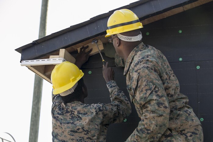 Cpl. Alatta Lawrence, left, and Lance Cpl. Thea Robertson, combat engineers with 8th Engineer Support Battalion, 2nd Marine Logistics Group, nail wood to the side of a building aboard Camp Lejeune, N.C., March 31, 2015. Engineers with 8th ESB built a storage facility for the unit’s martial arts equipment as training for an upcoming deployment. The Marines will use the same skills to construct schools and other facilities overseas. (U.S. Marine Corps photo by Cpl. Elizabeth A. Case/Released)