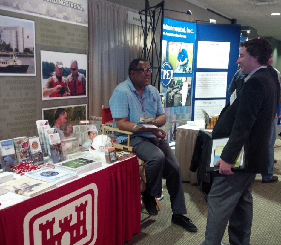 Gerald Rogers, public affairs specialist with the Norfolk District, talks about the Corps environmental mission with an attendee at the Virginia Environmental Symposium, April 1. 