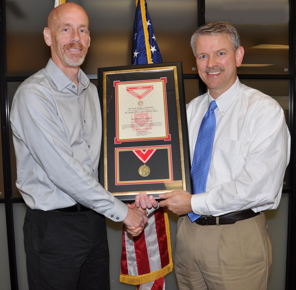 U.S. Army Engineer Research and Development Center Geotechnical and Structures Laboratory Deputy Director Dr. Bill Grogan is presented with the Bronze Order of the de Fleury Medal by former GSL Director and current ERDC Deputy Director Dr. David Pittman. 