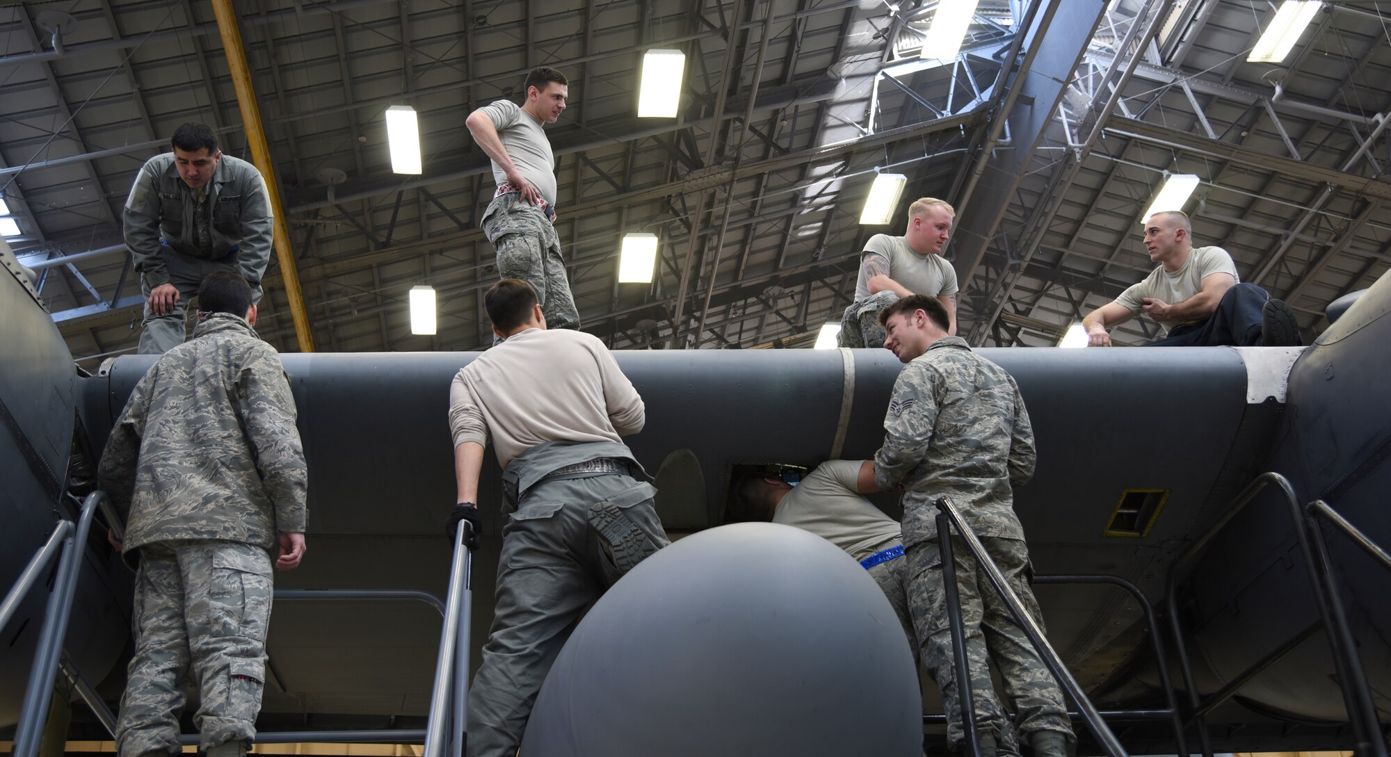 Eight Airmen from various maintenance units work on getting a leading edge attached to the wing of a C-130 Hercules, number 2067, at Yokota Air Base, Japan, March 11, 2015. The Airmen worked for more than two months and an estimated 5,000 man-hours on repairing the internals of 2067’s wing, which had extensive damage. (U.S. Air Force photo by Senior Airman Michael Washburn/Released) 