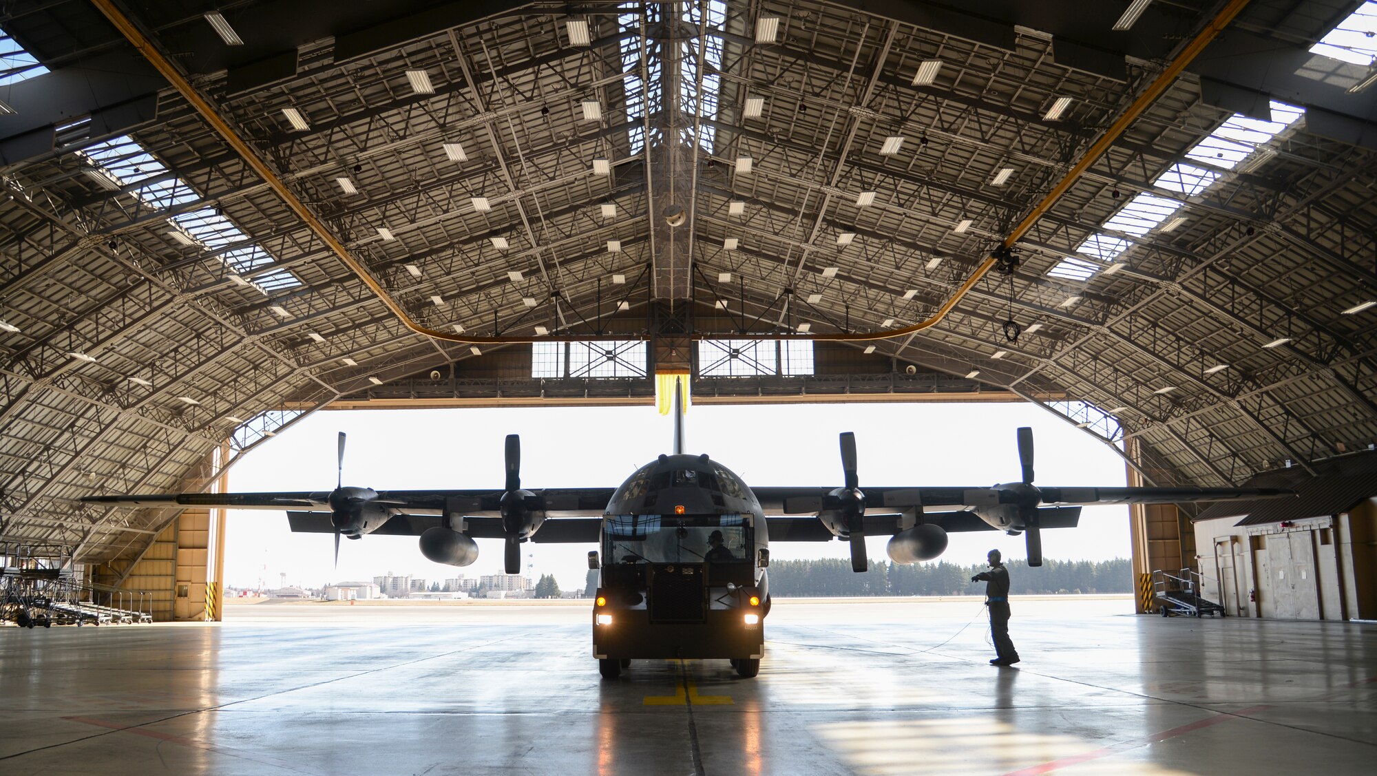 A C-130 Hercules, number 2067, sits inside a hangar in preparation of its final repairs at Yokota Air Base, Japan, March 11, 2015. An internal explosion in the wing severely crippled the aircraft. A team of eight Airmen, including the dedicated crew chief, were tasked with rebuilding 2067. (U.S. Air Force photo by Senior Airman Michael Washburn/Released)