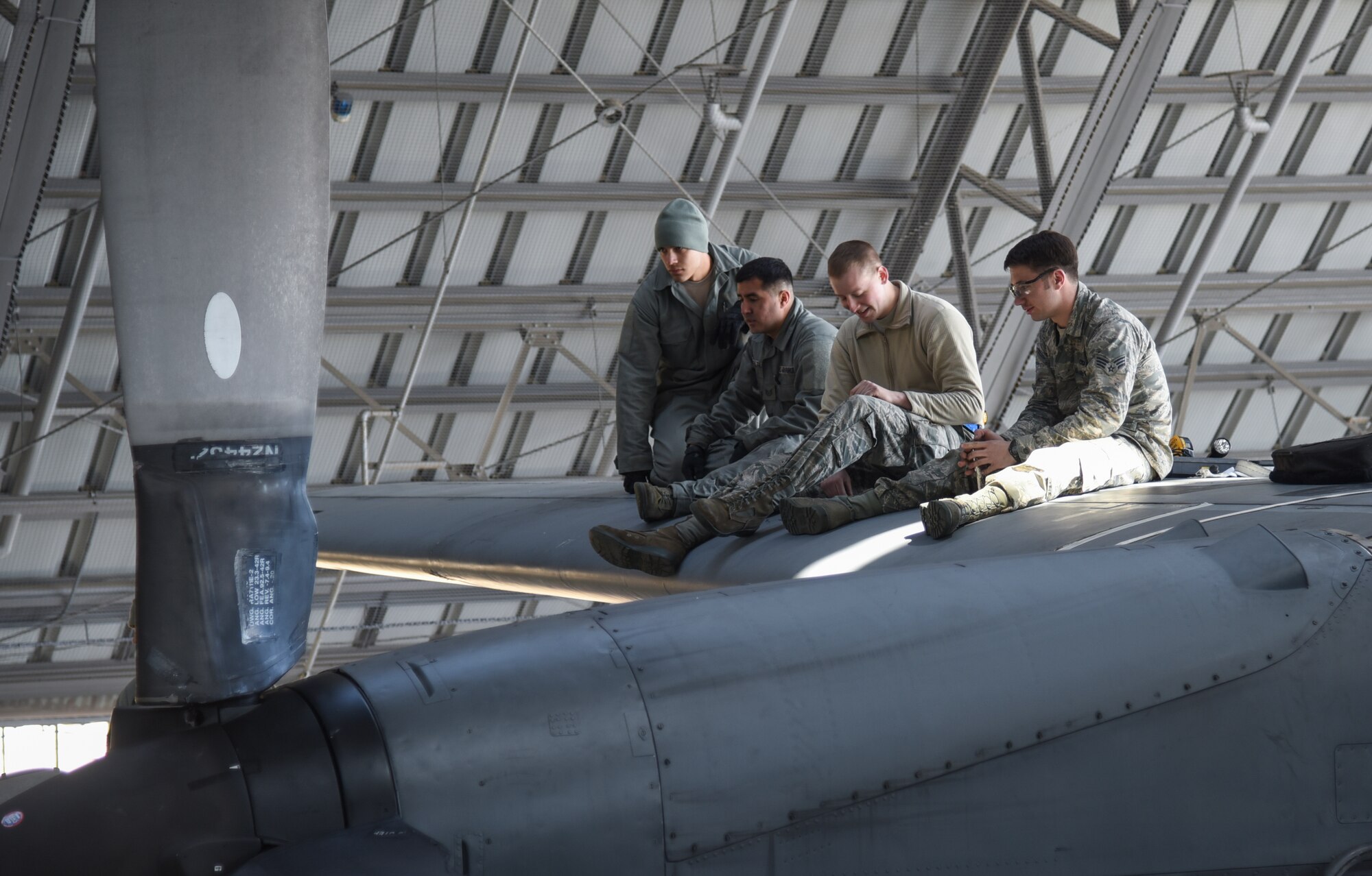 Airmen from the 374th Aircraft Maintenance Squadron, sit atop the wing of C-130 Hercules, number 2067, at Yokota Air Base, Japan, March 11, 2015. The C-130 suffered catastrophic damage to the wing section, which required a complete rebuild. (U.S. Air Force photo by Senior Airman Michael Washburn/Released)