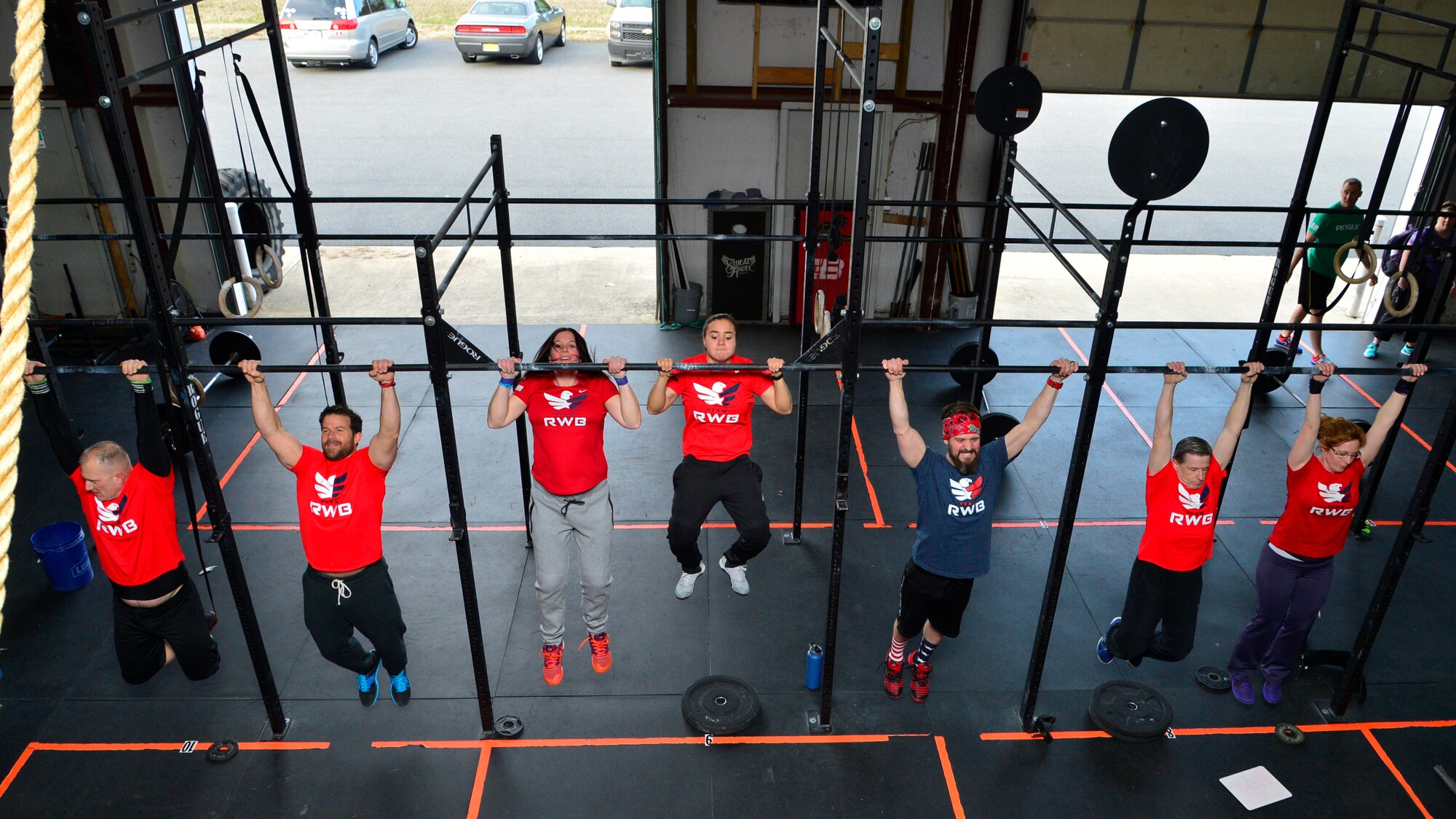 Members of Team Red, White and Blue perform pull-ups during a workout April 2, 2015, at CrossFit Sweat Angel in Camden, Del. Members of Team RWB meet every Thursday at the gym in their RWB shirts to perform high intensity workouts together. (U.S. Air Force photo/Airman 1st Class William Johnson)