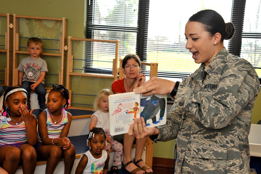 U.S. Air Force 2nd Lt. Jori Walan, 28th Operational Weather Squadron weather officer, reads to a group of children as part of the Month of the Military Child kickoff event at the McElveen Information Resource Center at Shaw Air Force Base, S.C., April 7, 2015. The Hispanic Organization for Latin Appreciation held a story time for young children, giving Airmen the opportunity to volunteer their time to help the next generation. (U.S. Air Force photo by Senior Airman Jonathan Bass/Released)