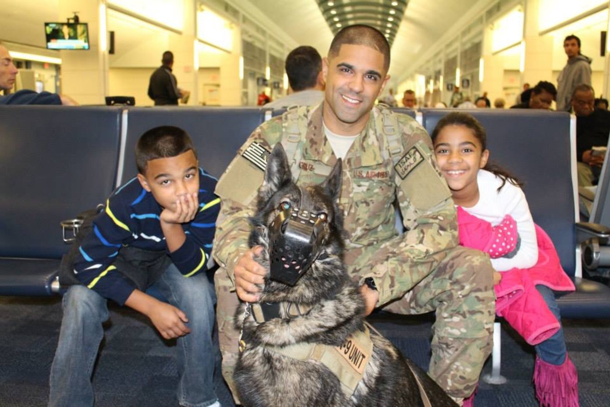 U.S. Air Force Staff Sgt. Anthony Cruz, middle, 23d Security Forces Squadron Military Working Dog handler, his children AJ and Jalene, and MWD Liza, pose for a photo prior to Cruz leaving for a pre-deployment training in 2013. Cruz and Liza deployed as a team to Southwest Asia. (Courtesy photo)