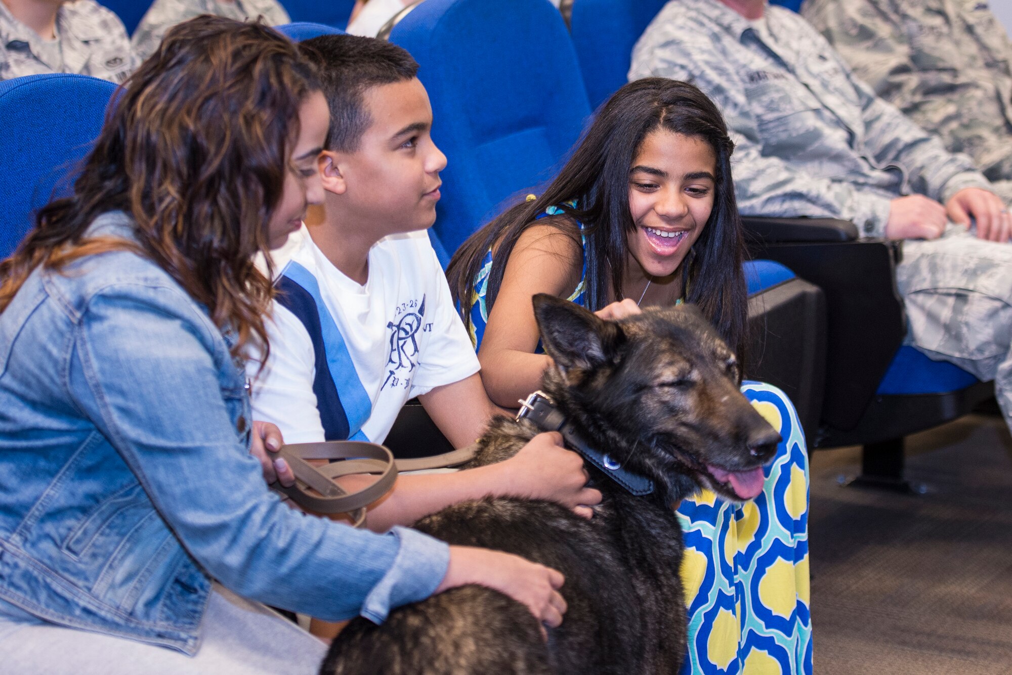 Johaira Cruz, left, wife of U.S. Air Force Staff Sgt. Anthony Cruz, 23d Security Forces Squadron Military Working Dog handler, and their children, A.J. and Jalene Cruz, pat their new dog Liza, retired MWD, April 2, 2015, at Moody Air Force Base, Ga. Liza will be adopted by the Cruz family after 10 years of service. (U.S. Air Force photo by Airman Greg Nash/Released)
