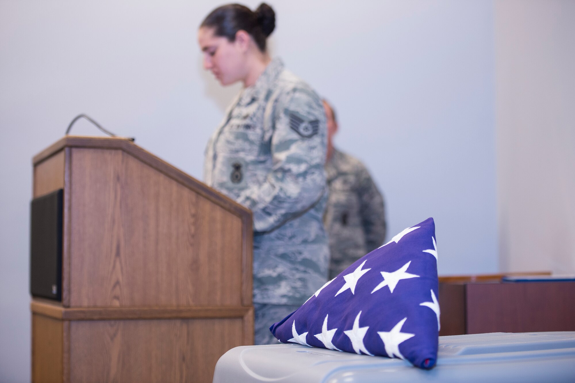 A U.S. flag rests on a dog kennel as U.S. Air Force Staff Sgt. Renee Mansour, 23d Security Forces Squadron military working dog handler, narrates during retired MWD Liza’s retirement ceremony April 2, 2015, at Moody Air Force Base, Ga. Liza was born in May 2004 and entered MWD training at Lackland AFB in August 2005. (U.S. Air Force photo by Airman Greg Nash/Released)