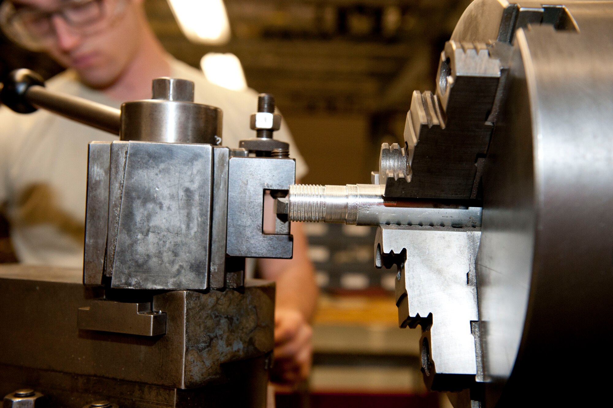 Airman 1st Class Philip Giampaolo, 49th Maintenance Squadron Aircraft Metals Technology apprentice, makes external threads on a workpiece at Holloman Air Force Base, N.M. April 6, 2015. Making external threads is called turning and is done by using a lathe. (U.S. Air Force photo by Staff Sgt. E’Lysia A. Wray/Released)
