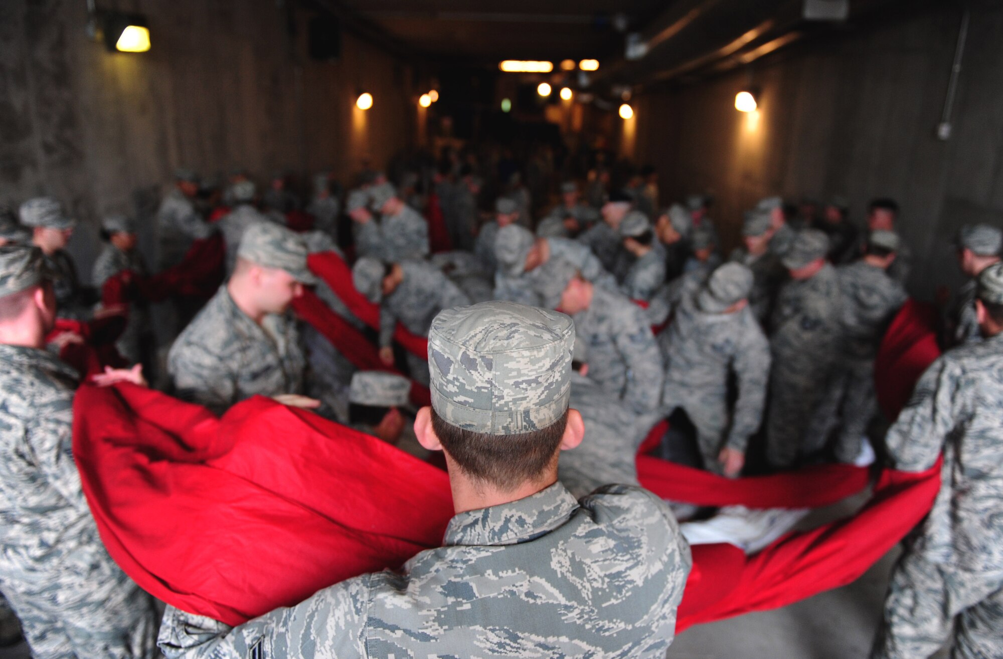 Airmen from Whiteman Air Force Base, Mo. pack away a large U.S. Flag after a flag detail during the Kansas City Royals opening day game at Kauffman Stadium April 6, 2015. More than 100 Airmen participated in the detail that was accompanied by the singing of the National Anthem and a B-2 Spirit flyover. (U.S. Air Force photo by Airman 1st Class Joel Pfiester/Released)