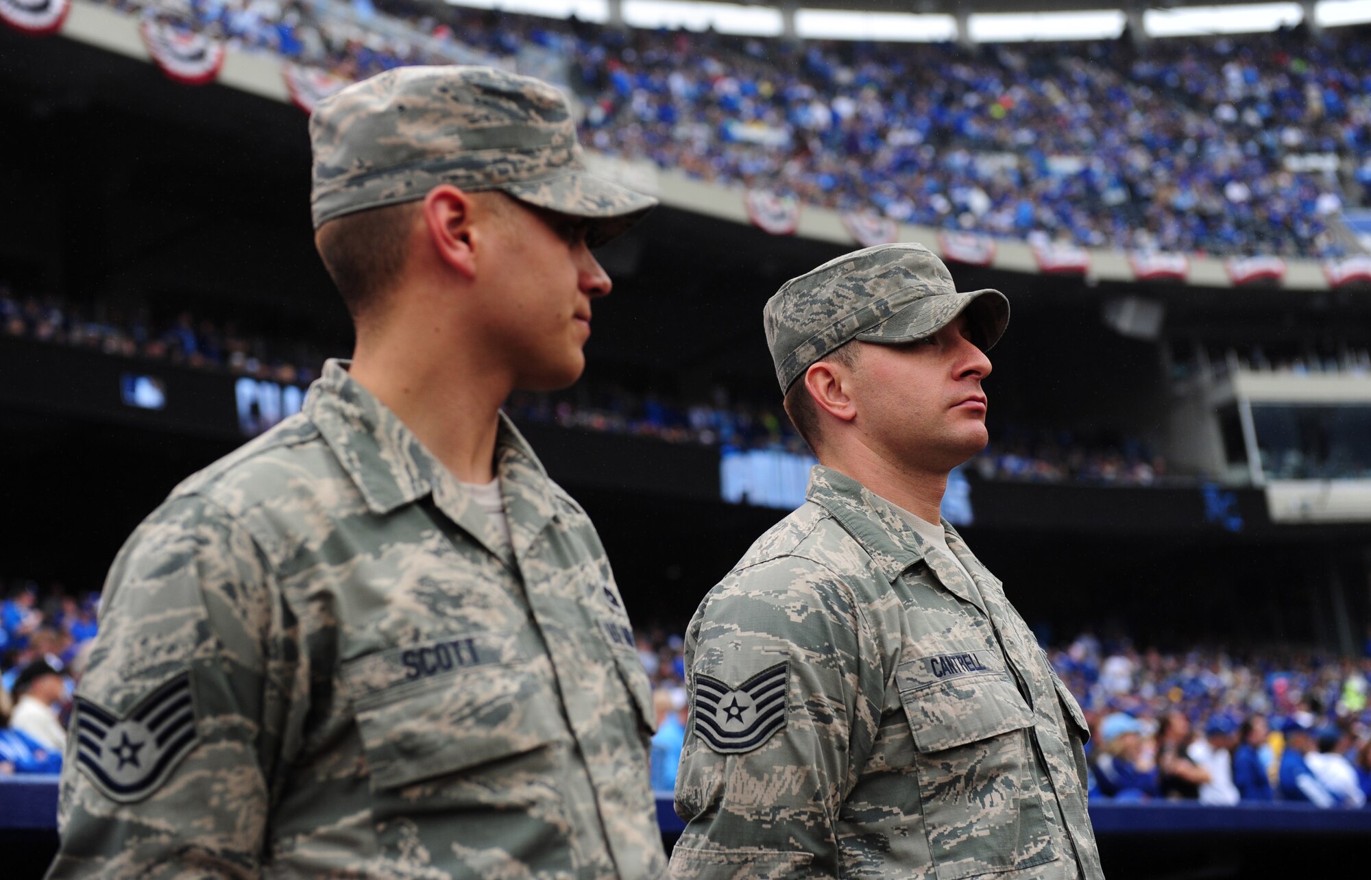 Staff Sgt. Harrison Scott, 509th Aircraft Maintenance Squadron dedicated crew chief and Tech Sgt. Joshua Cantrell, 131st AMXS dedicated crew chief, stand on the field at Kauffman Stadium during the Kansas City Royals 2015 opening day game April 6, 2015. Airmen from Whiteman Air Force Base, Mo. took part in a flag detail before the game. (U.S. Air Force photo by Airman 1st Class Joel Pfiester/Released)