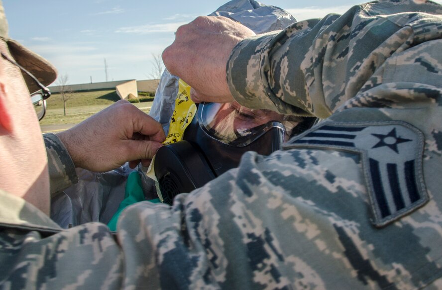 Senior Airman Nick Bouselli assists Senior Airman Kevin Klingelhoefer, both are 92nd Civil Engineer Squadron emergency managers, don his chemical protection equipment before conducting chemical, biological and radiological assessments of a simulated “exposed” building as part of an emergency management exercise March 30, 2015, at Fairchild Air Force Base, Wash. Exercises like these give Fairchild personnel a chance to experience what is expected during a real world incident and the ability to perform these skills in a safe, training environment. (U.S. Air Force photo/Staff Sgt. Benjamin W. Stratton)