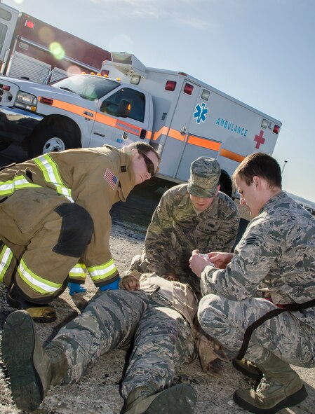 Fairchild emergency responders see to the simulated injuries of Airman 1st Class Jauna Williams, a 92nd Force Support Squadron services specialist, as part of an emergency management exercise March 30, 2015, at Fairchild Air Force Base, Wash. Fairchild conducts similar exercises regularly to maintain a high level of preparedness to ensure the installation is always able to provide responsive, precise air refueling and operational support for the full range of military operations. (U.S. Air Force photo/Staff Sgt. Benjamin W. Stratton)
