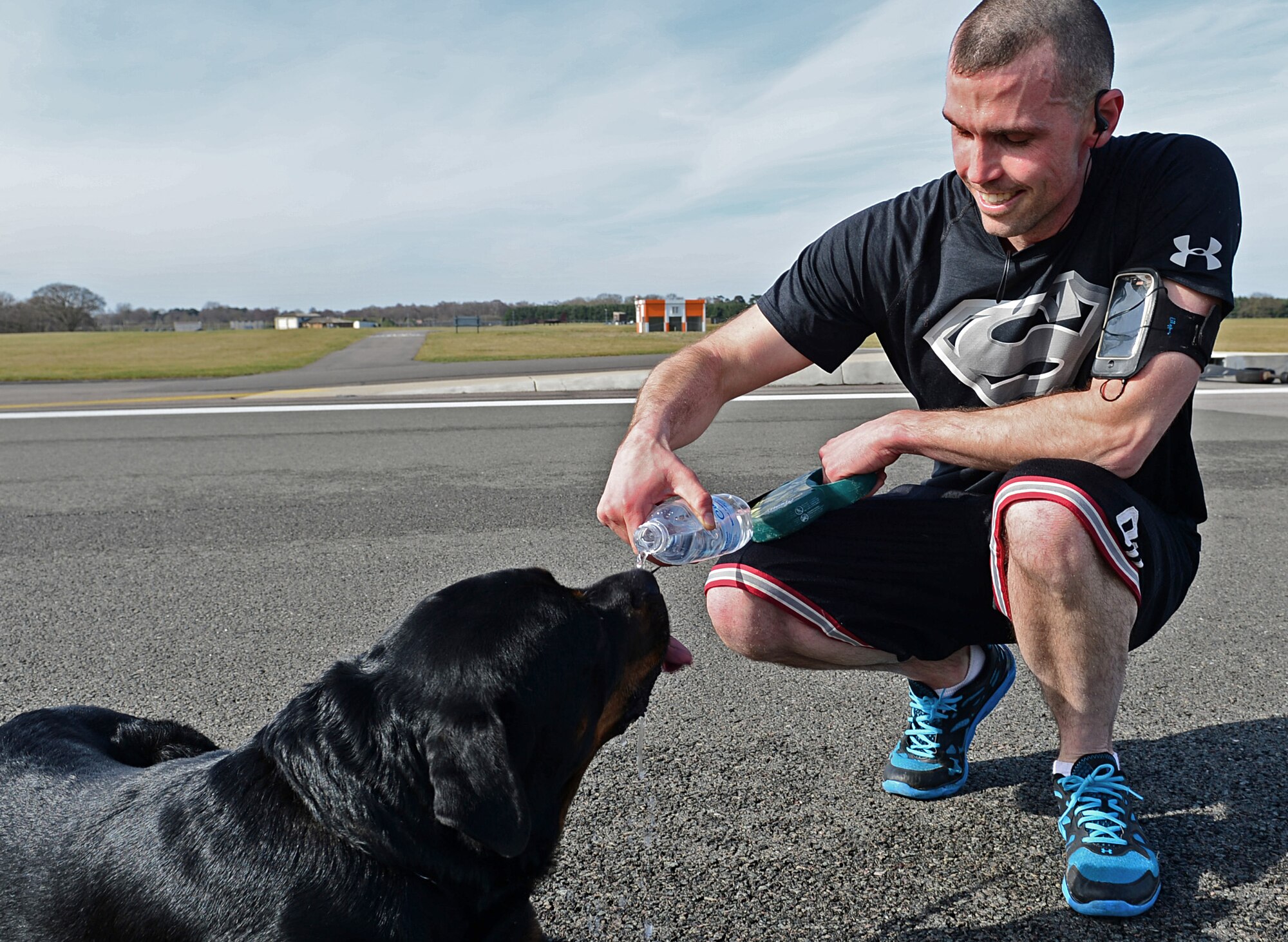 Tech. Sgt. Christopher Fisher, 48th Civil Engineer Squadron NCO in charge of pavements and equipment, gives water to his Rottweiler during a 5K memorial run in memory of Tech. Sgt. Phillip Myers, an EOD craftsman, at Royal Air Force Lakenheath, England, April 2, 2015. Myers gave his life in the line of duty while deployed to Afghanistan April 4, 2009. (U.S. Air Force photo by Airman 1st Class Erin R. Babis/Released)