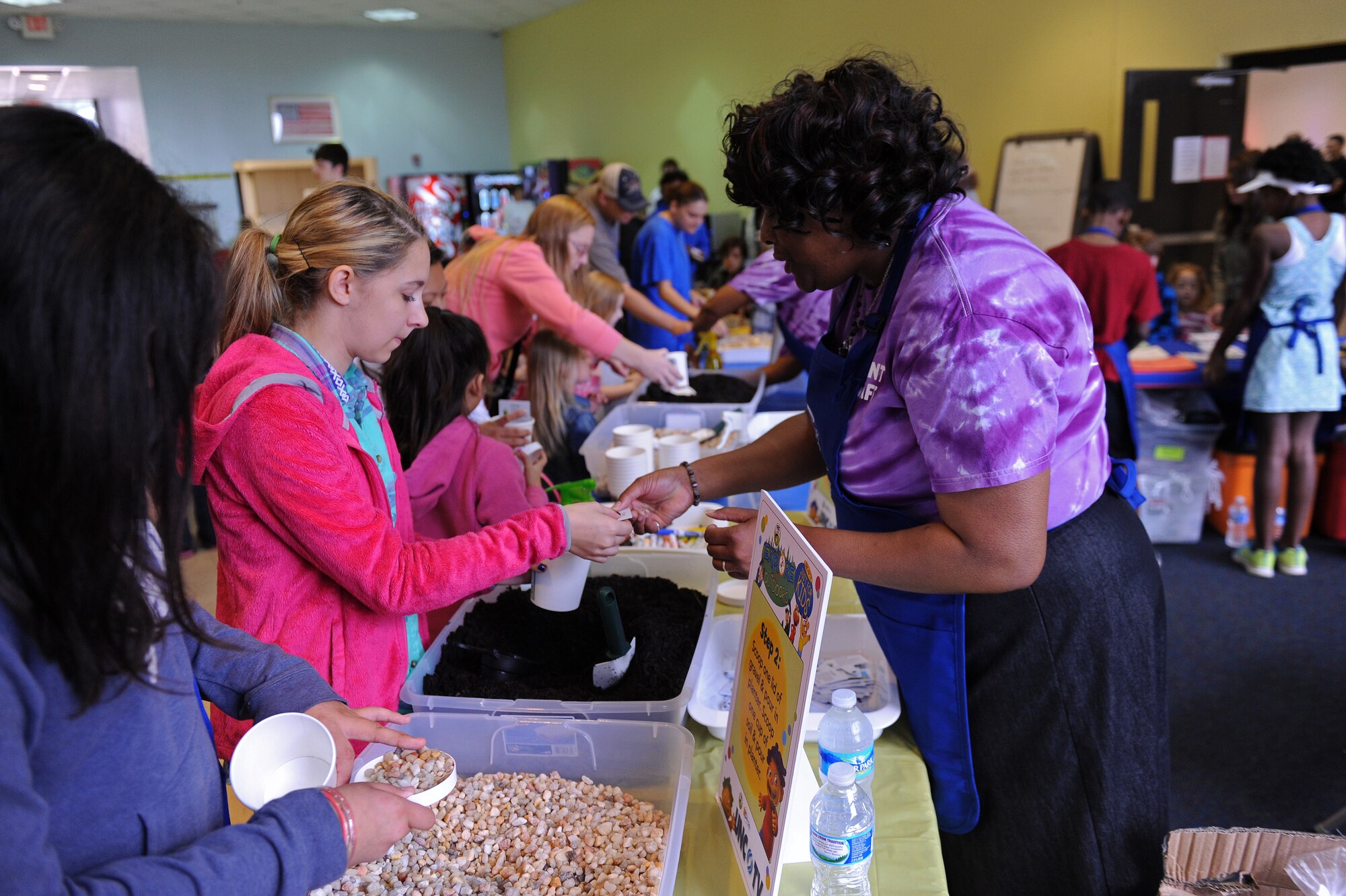 Sondra Russell, UNC TV volunteer, helps children plant chives during the Month of the Military Child kickoff event April 4, 2015, at Seymour Johnson Air Force Base, North Carolina. More than 30 community members volunteered at the event to show their support for military families. (U.S. Air Force photo/Airman 1st Class Aaron J. Jenne)