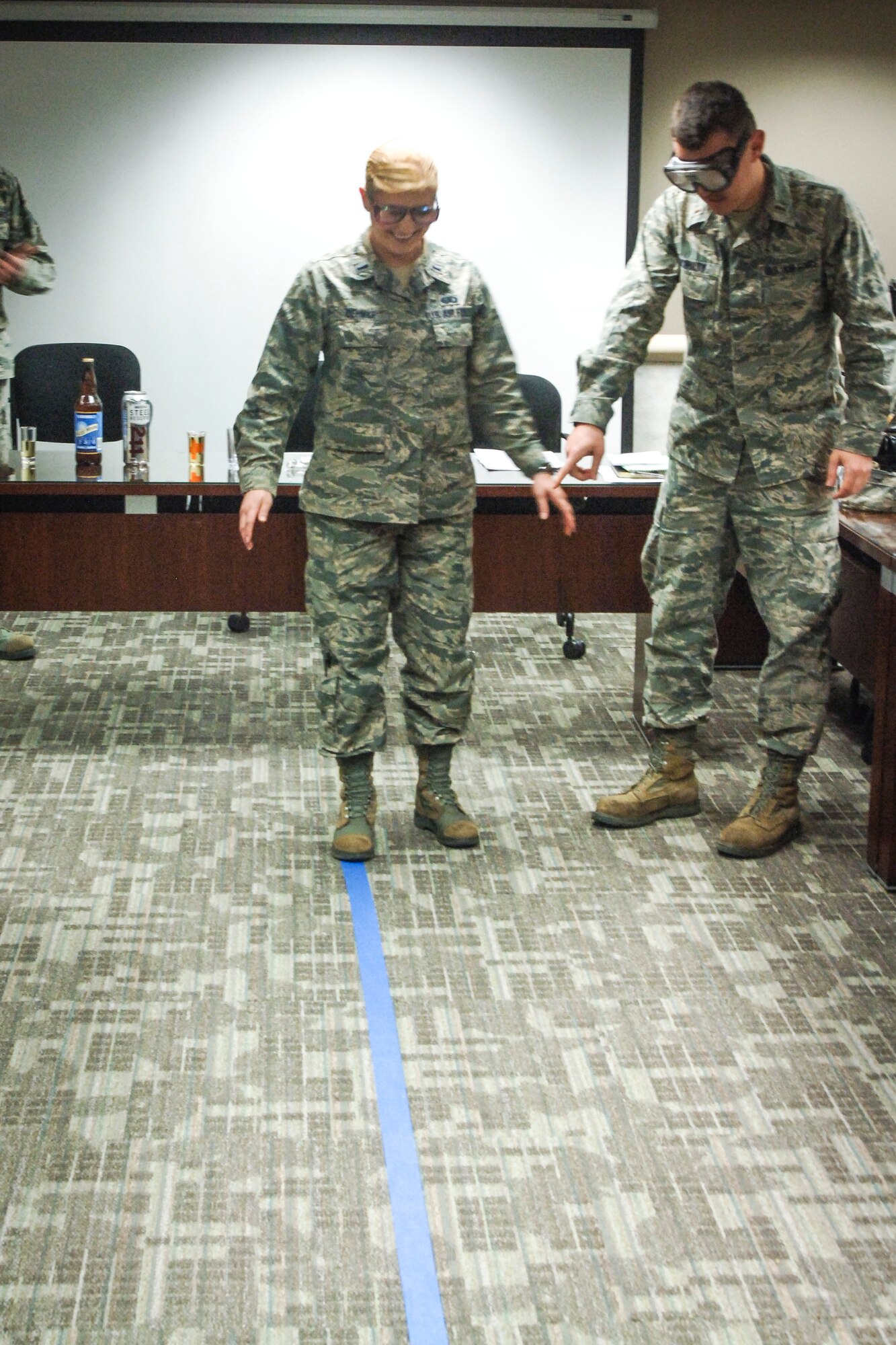 2nd Lt. Sergei McNulty, 92nd Operations Support Squadron intelligence officer helps 1st Lt. Evelyn Oehmke, 92nd Force Support Squadron military personnel section chief, walk a straight line while they both wear impairment goggles during the CGO Mission Orientation Brief March 24, 2015 at Fairchild AFB, Wash. CGOs listened to a briefing on alcohol and drug awareness during their visit to the 92nd Medical Group. (U.S. Air Force photo/2nd Lt. Shelley Gregory)