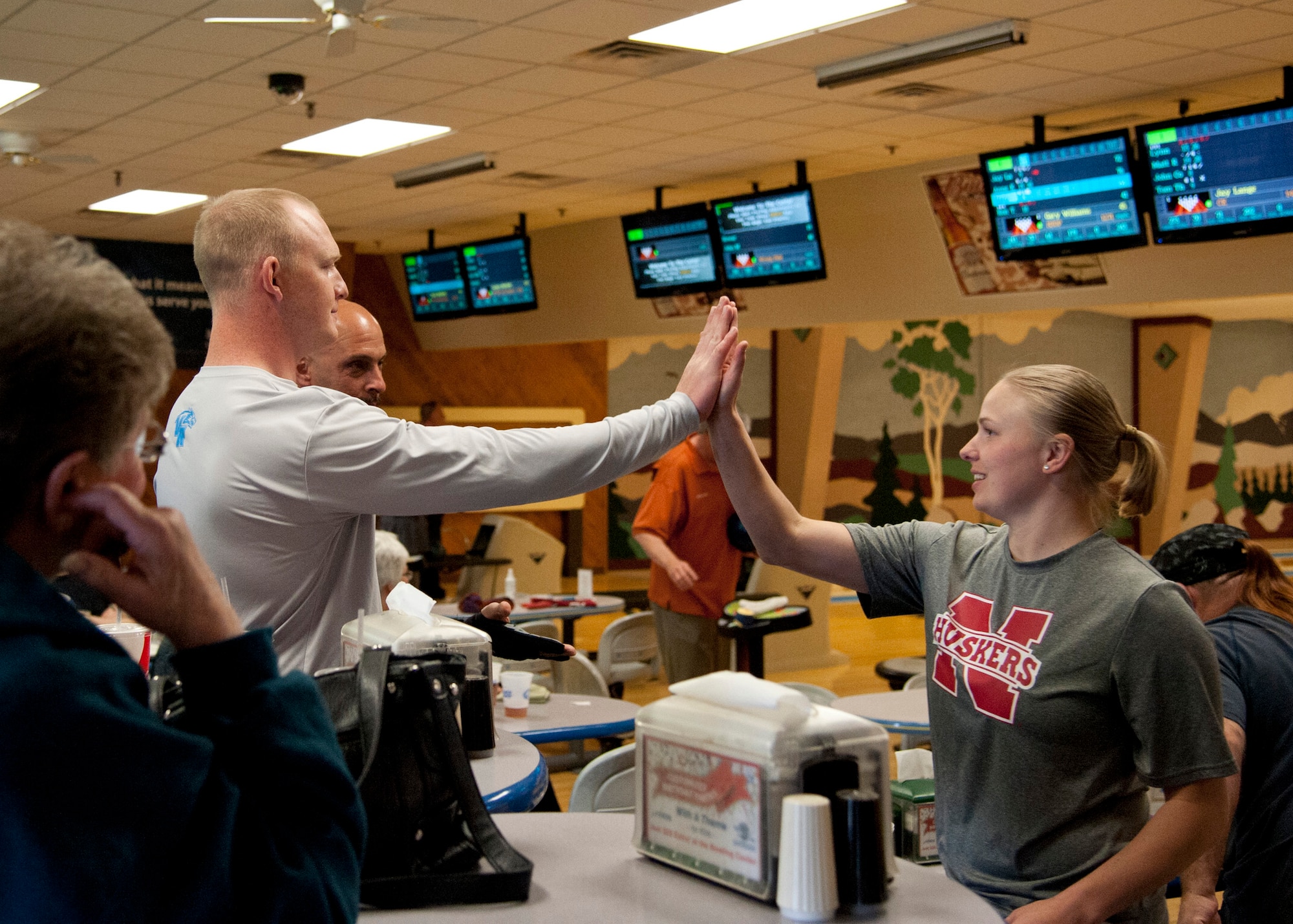 PETERSON AIR FORCE BASE, Colo. – Staff Sgt. Kyle Kelly, 21st Communications Squadron, high fives his sister, Staff Sgt. Kayla Miller, 21st Operations Support Squadron, during a bowling league game at the Peterson bowling center April 1, 2015. Kelly and Miller are stationed together for the second time in their careers and are on the same bowling team, 9 Pin Power. (U.S. Air Force photo by Senior Airman Tiffany DeNault)