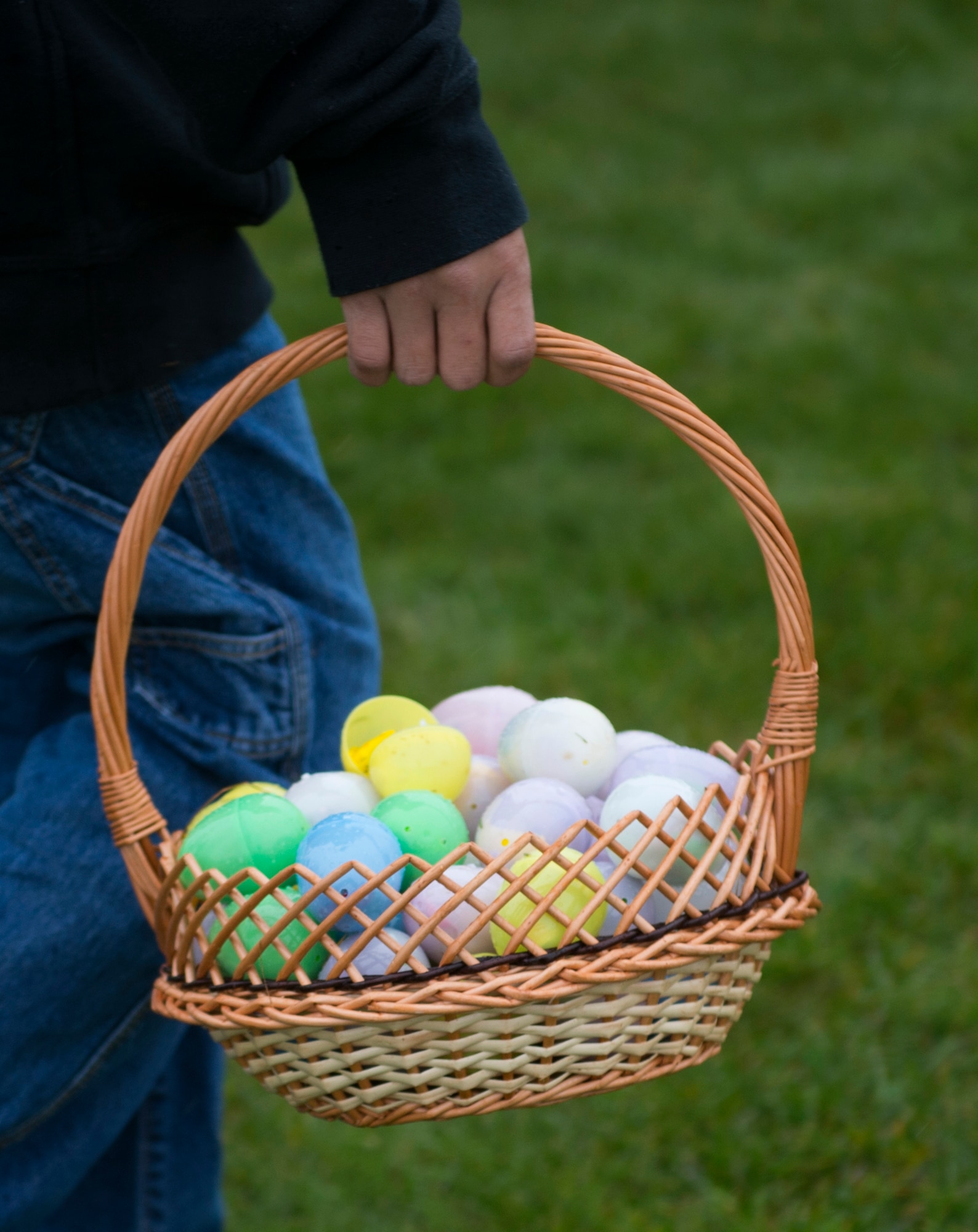 A participant in an Easter egg hunt holds a basket of plastic eggs on the grass field outside Club Eifel at Spangdahlem Air Base, Germany, April 4, 2015. The plastic eggs contained candy, toys and other prizes. (U.S. Air Force photo by Airman 1st Class Luke Kitterman/Released)