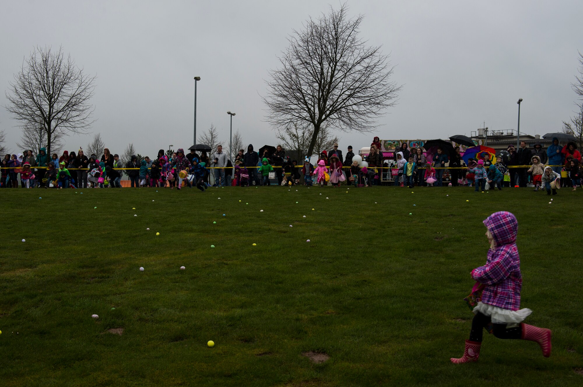 Children run toward plastic eggs at the start of an Easter egg hunt on the grass field outside Club Eifel at Spangdahlem Air Base, Germany, April 4, 2015. More than 300 people attended the event. (U.S. Air Force photo by Airman 1st Class Luke Kitterman/Released)