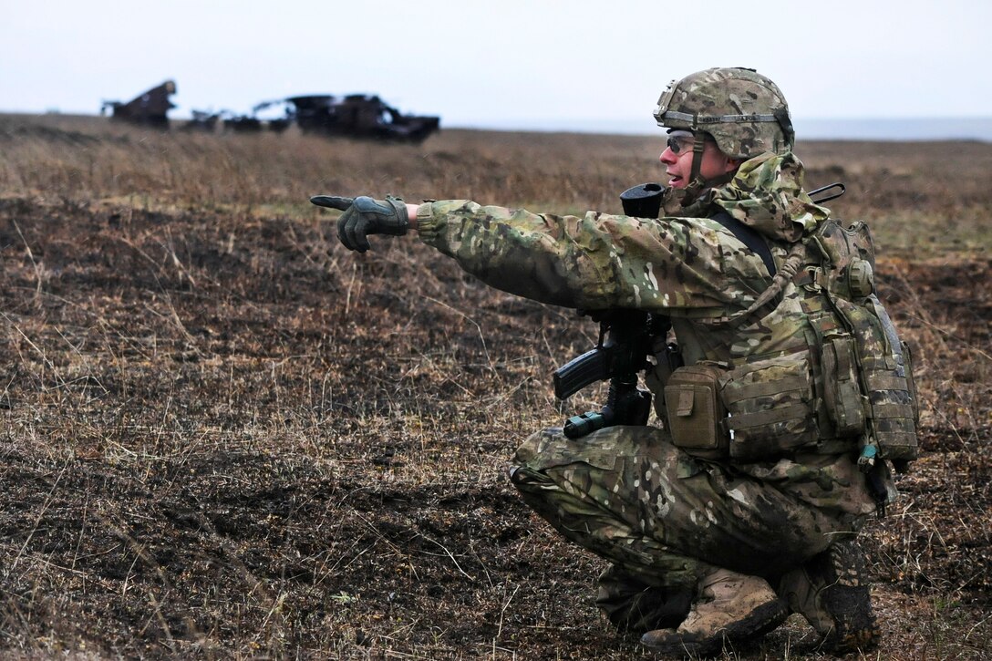 U.S. Army Sgt. Kevin Bullock directs soldiers toward their objective during a live-fire exercise at Smardan Training Area, Romania, April 6, 2015. Bullock is an infantryman assigned to 2nd Squadron, 2nd Cavalry Regiment.