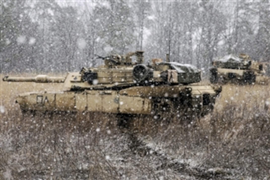 Two M1A1 Abram tanks sit on a snowy hill during a Marine Corps Combat readiness evaluation on Fort Pickett, Va., March 28, 2015. The tanks are assigned to the 2nd Marine Division's 2nd Tank Battalion.