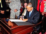 Massachusetts Gov. Deval Patrick signs legislation designating the city of Salem as the birthplace of the National Guard as local and state legislature, veterans groups and members of the Massachusetts National Guard look on during an official ceremony held at the Salem city hall, Aug. 19, 2010. The origins of the National Guard are traced back to Salem Common, the location of the fist muster of militiamen in 1637.