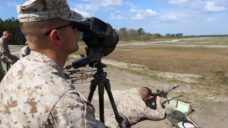 Captain Samuel Lutz, a ground intel officer with 1st Battalion, 2nd Marine Regiment, spots Cpl. Benjamin Schorr's shots during an unknown distance shoot with the M40A5 Bolt-Action Sniper Rifle aboard Camp Lejeune, April 6, 2015. The snipers used the M40A5 and the M110 Semi-Automatic Sniper Rifle during their firing exercise. 