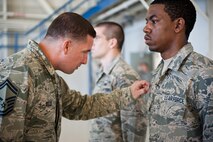 Senior Master Sgt. Jason Sells, 33rd Maintenance Group wing weapons manager, finds a string on Airman 1st Class Robert Hughes, 58th Aircraft Maintenance Unit crew one crew member, during a uniform inspection before a weapons load competition on Eglin Air Force Base, Florida, April 3, 2015. This was the 33rd Fighter Wing’s first weapons load competition since the 2009 draw down of the F-15C Eagle mission. (U.S. Air Force Photo/Staff Sgt. Marleah Robertson)