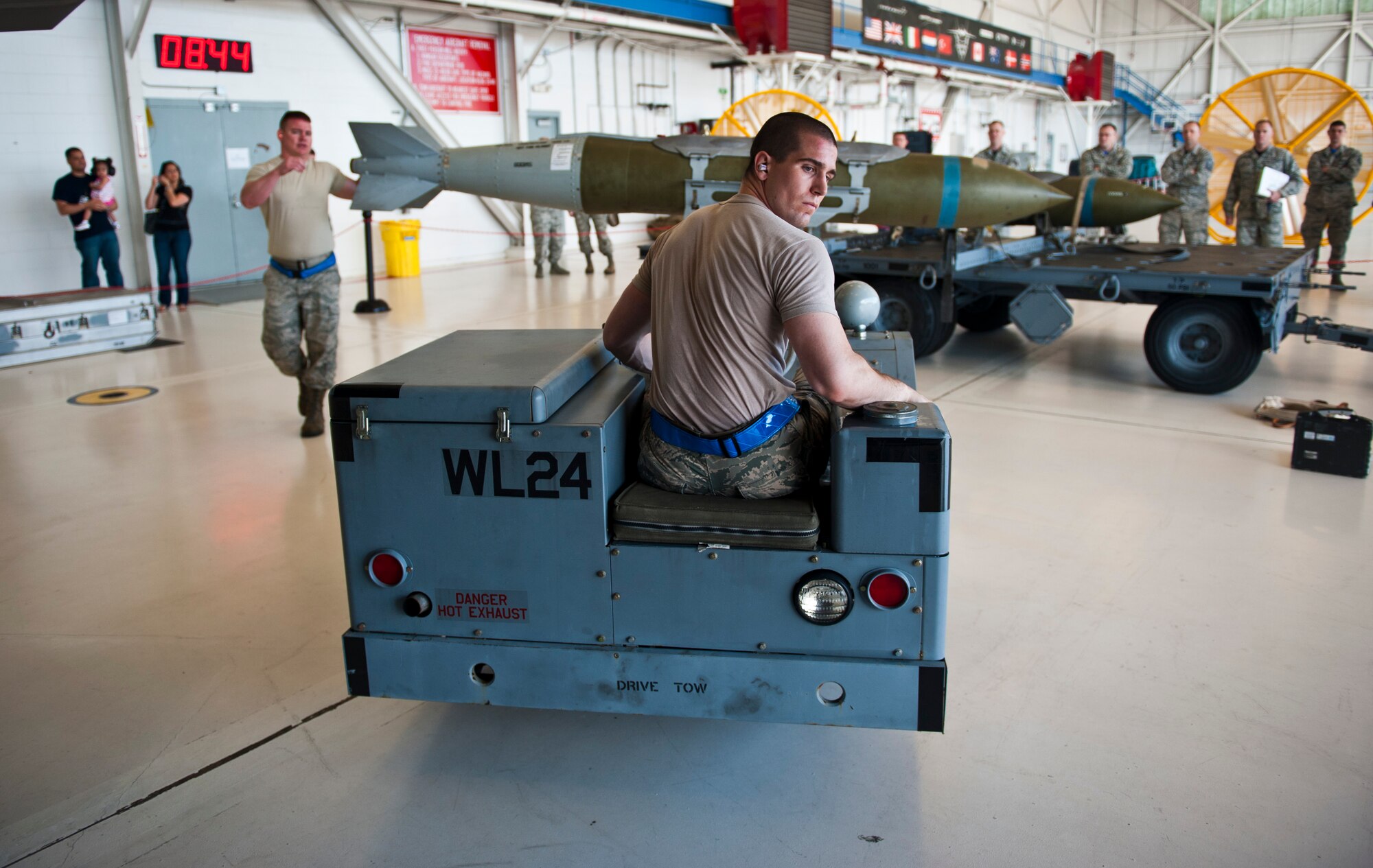 Airman 1st Class Reece Zoller, left, 58th Aircraft Maintenance Unit crew one load crew member, operates an MJ-1 lift truck carrying a GBU-31 Joint Direct Attack Munition as Staff Sgt. Zachary Watts, 58 AMU crew one load crew chief, guides him during a weapons load competition on Eglin Air Force Base, Florida, April 3, 2015. During weapons load competitions, crews are evaluated on how well they load munitions safely, efficiently and in a timely manner as a team. (U.S. Air Force Photo/Staff Sgt. Marleah Robertson)